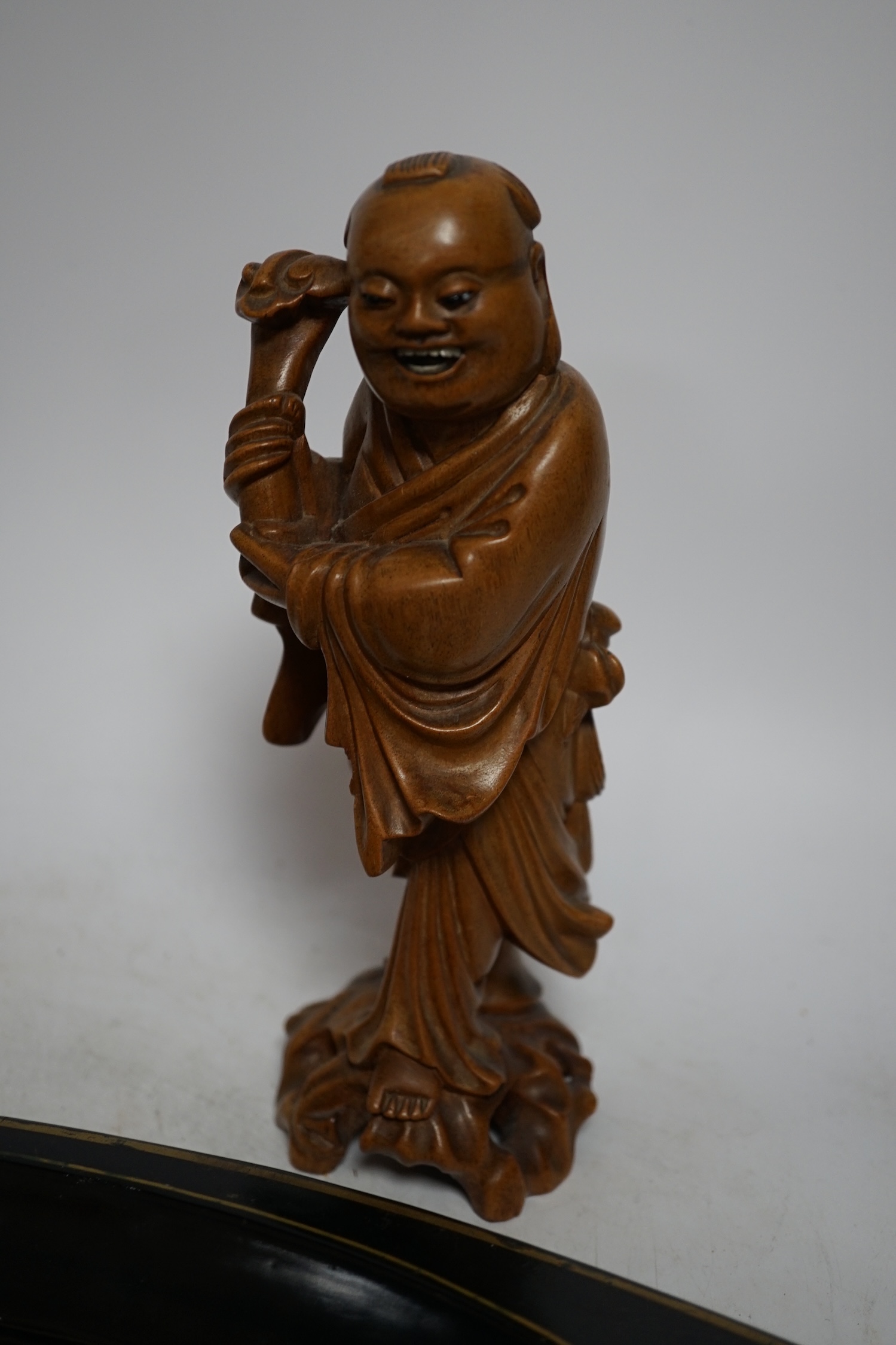 An oval japanned toleware tray and a pair of Chinese carved wood figures, largest 61cm wide